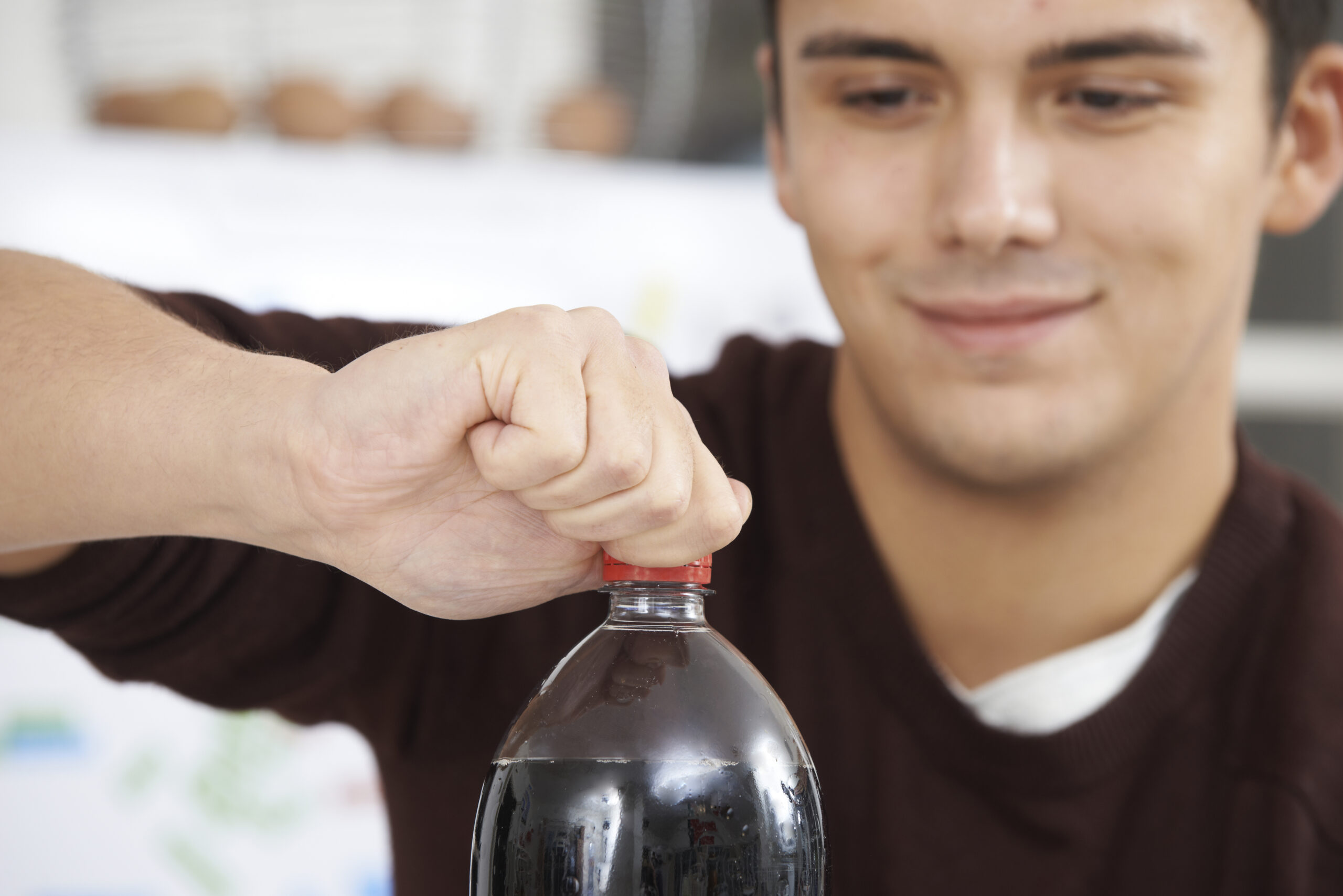 Young Man Opening Bottle Of Soda