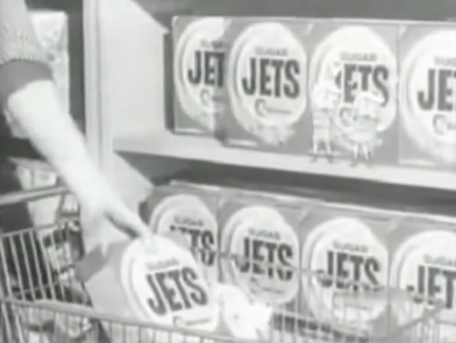 Boxes of Sugar Jets cereal on shelves, one being put in a cart. From old commercial, posted to YouTube by compukatz