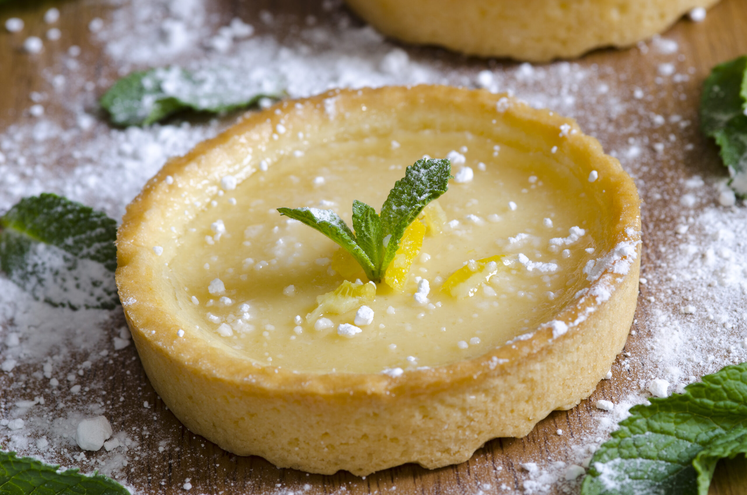 A lemon tart with mint and icing sugar