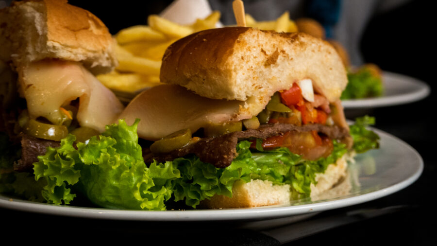 Chivito is an uruguayan beef sandwich, that includes lettuce, tomato, bacon, ham, red pepper, fried eggs, mozzarella cheese, olives 