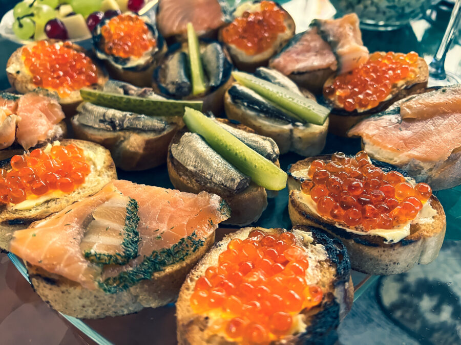 bread topped with fish, caviar, salmon and cucumbers.
