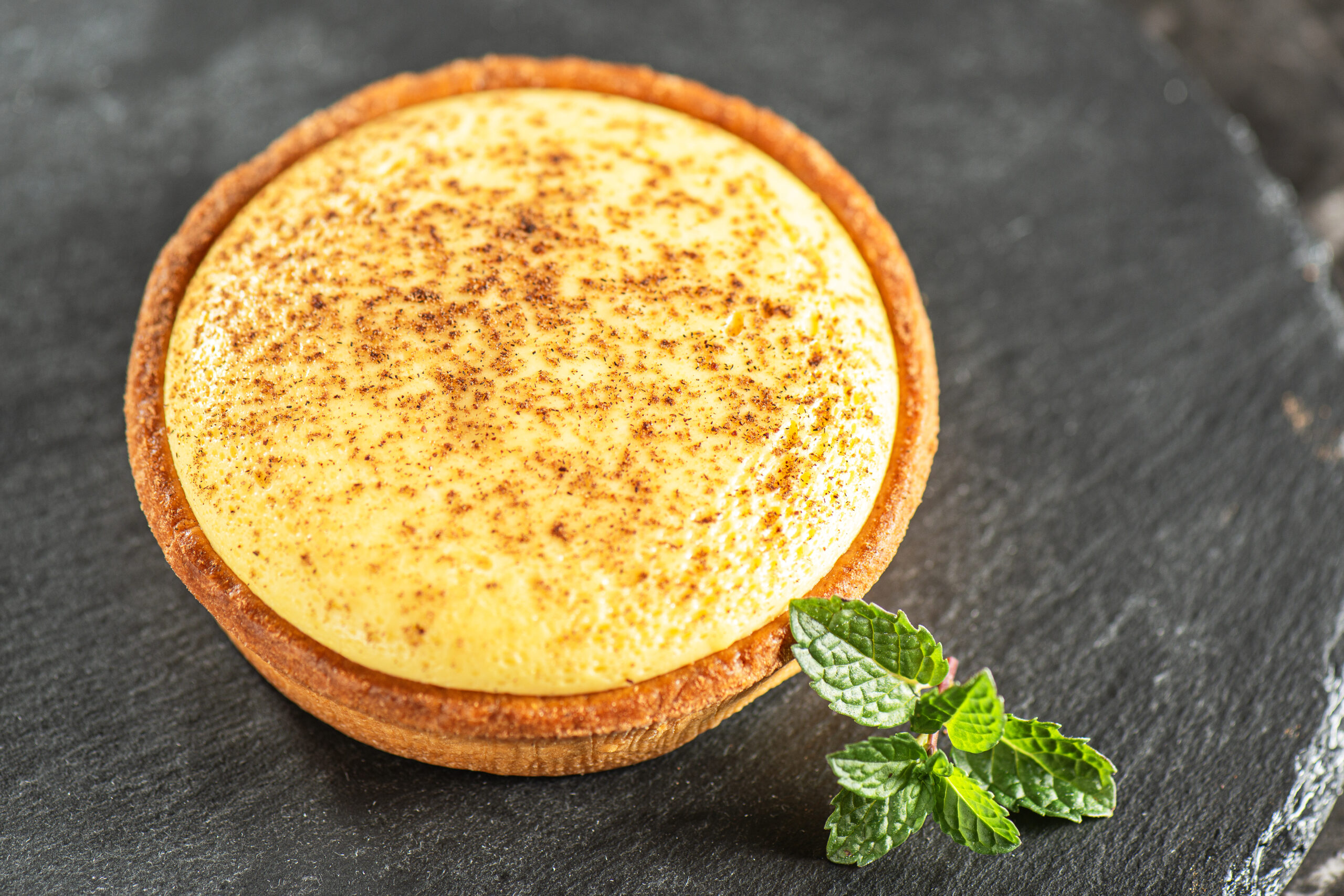 Delicious freshly baked custard tart sprinkled with ground nutmeg