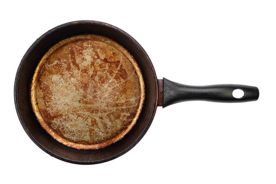 Dirty old frying pan on white background. Top view.