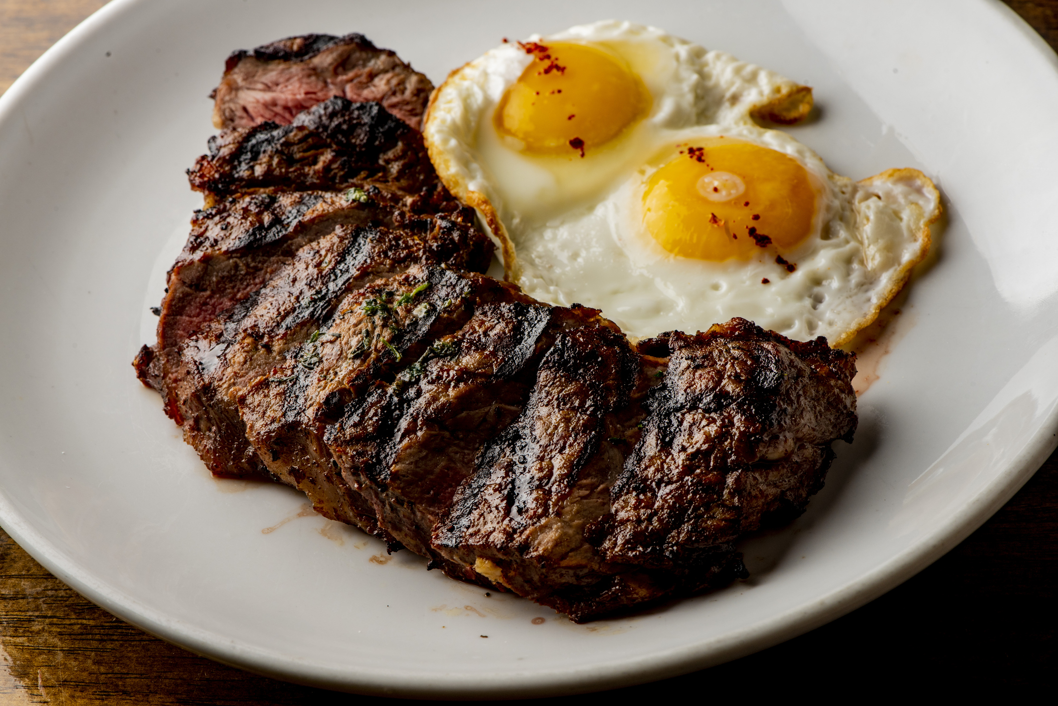 Steak and eggs. Traditional classical American diner or French Bistro brunch item, steak and eggs with tots. Angus steak served medium rare with fried eggs and crispy seasoned home fries.