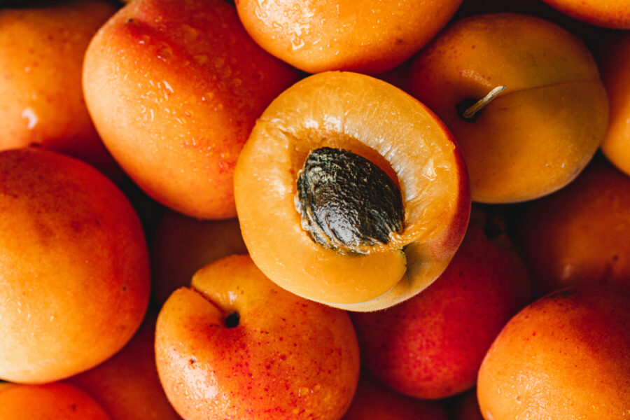 Full frame of fresh apricots with half slice. Close-up of ripe apricots.