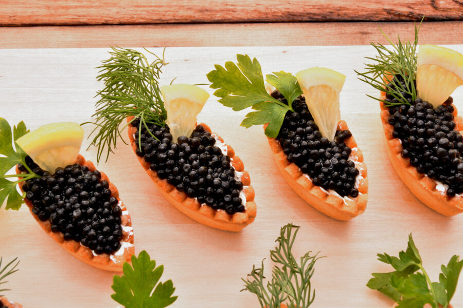 Tartlets with black caviar and fresh greens