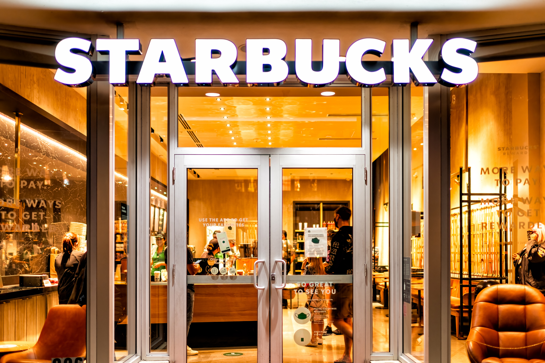 Miami Beach, USA - January 20, 2021: Famous Lincoln road shopping street with sign entrance exterior for Starbucks coffee cafe restaurant store in Florida