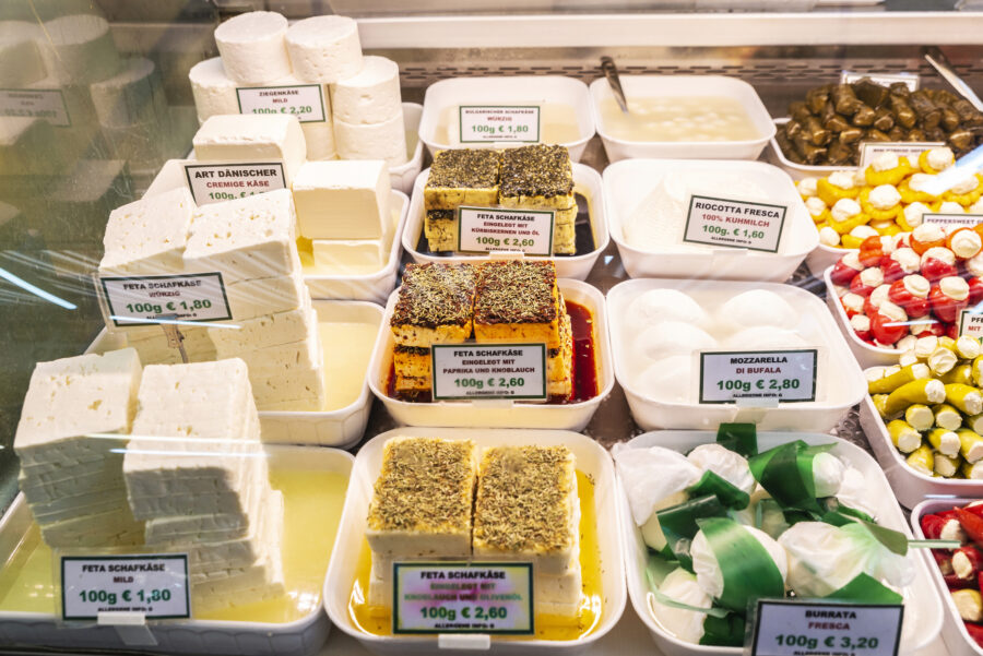 cheeses being sold, with signs labeling them