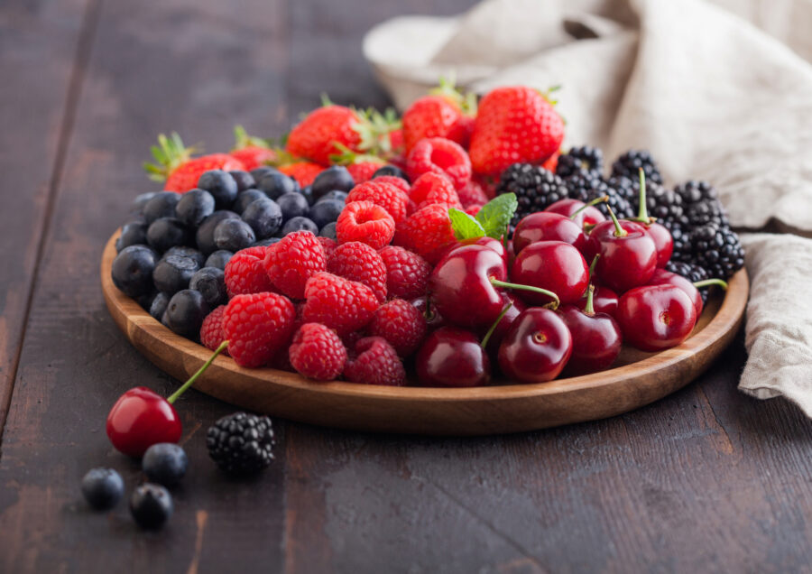 Raspberries, strawberries, blueberries, blackberries and cherries with linen kitchen towel.  Top view