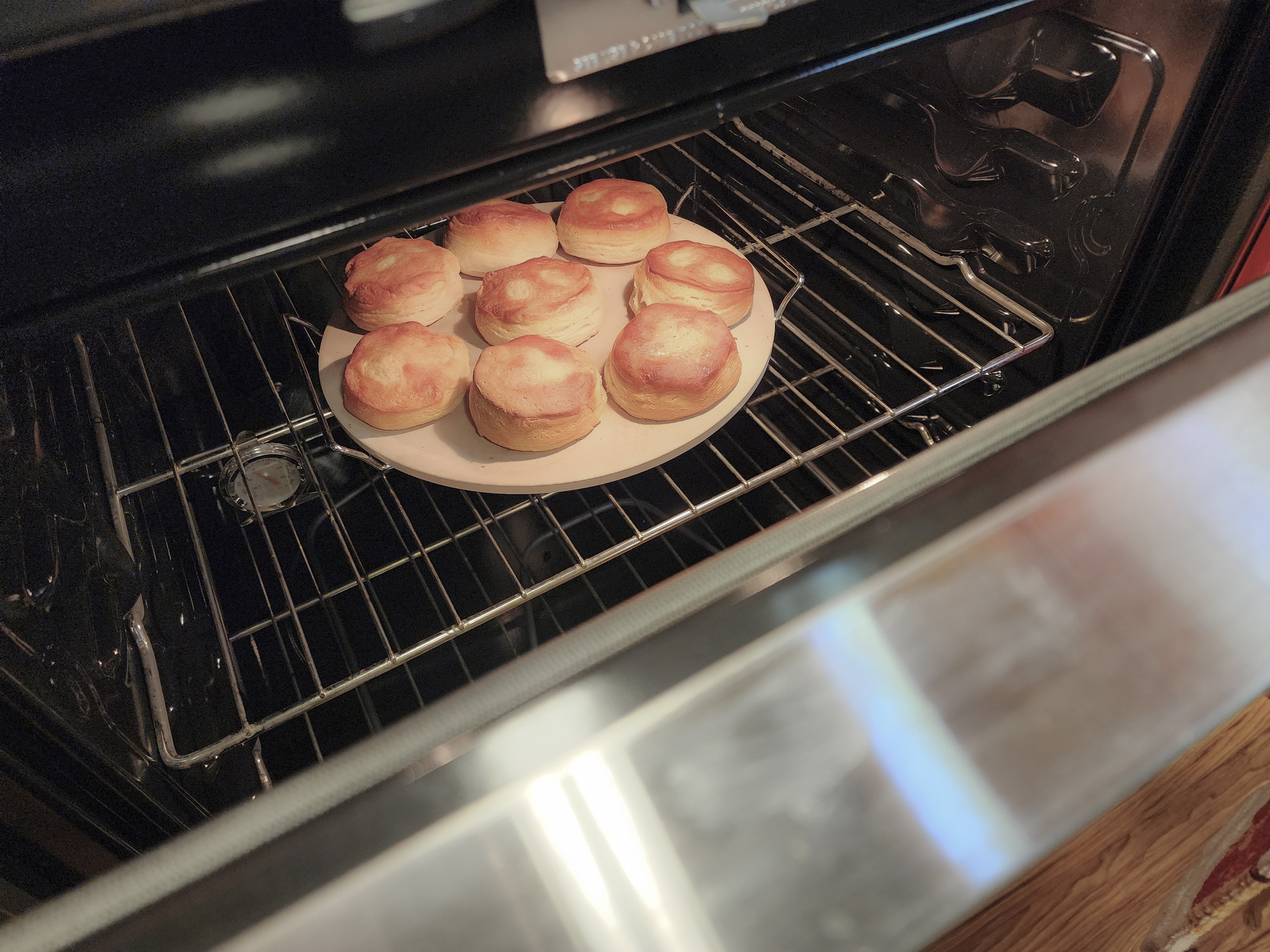 Biscuits baking in oven. View through the oven door window.