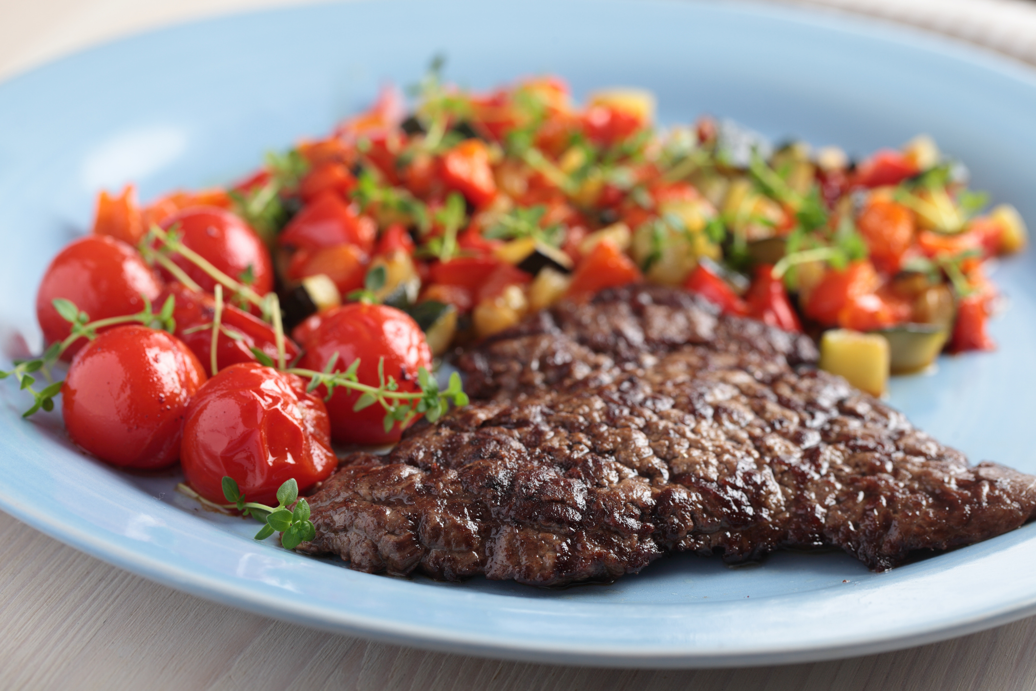 Beef steak with ratatouille, cherry tomatoes, and thyme