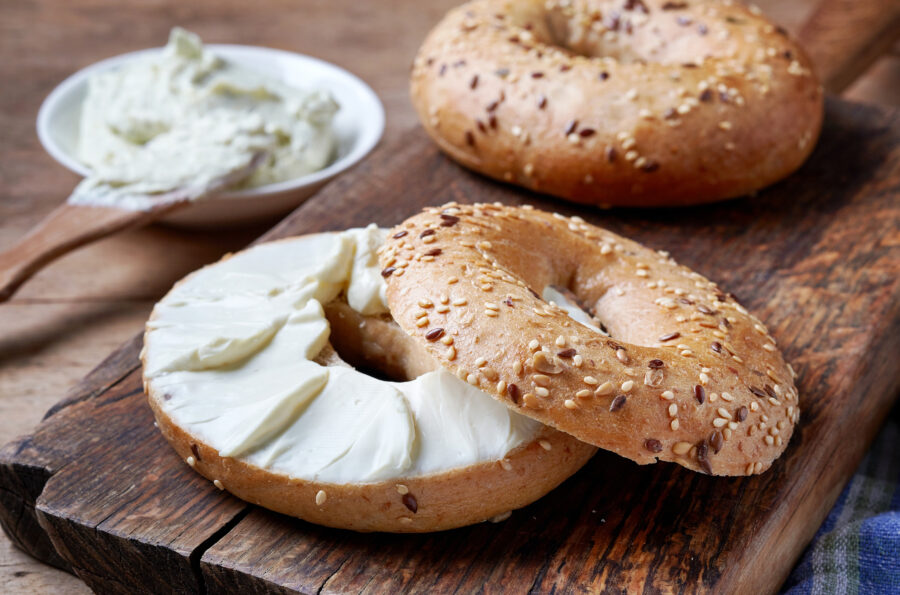 Bagel with cream cheese on wooden table