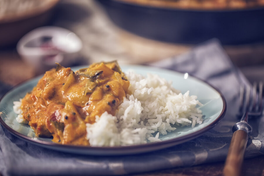 chicken curry dish with basmati rice served on a plate.