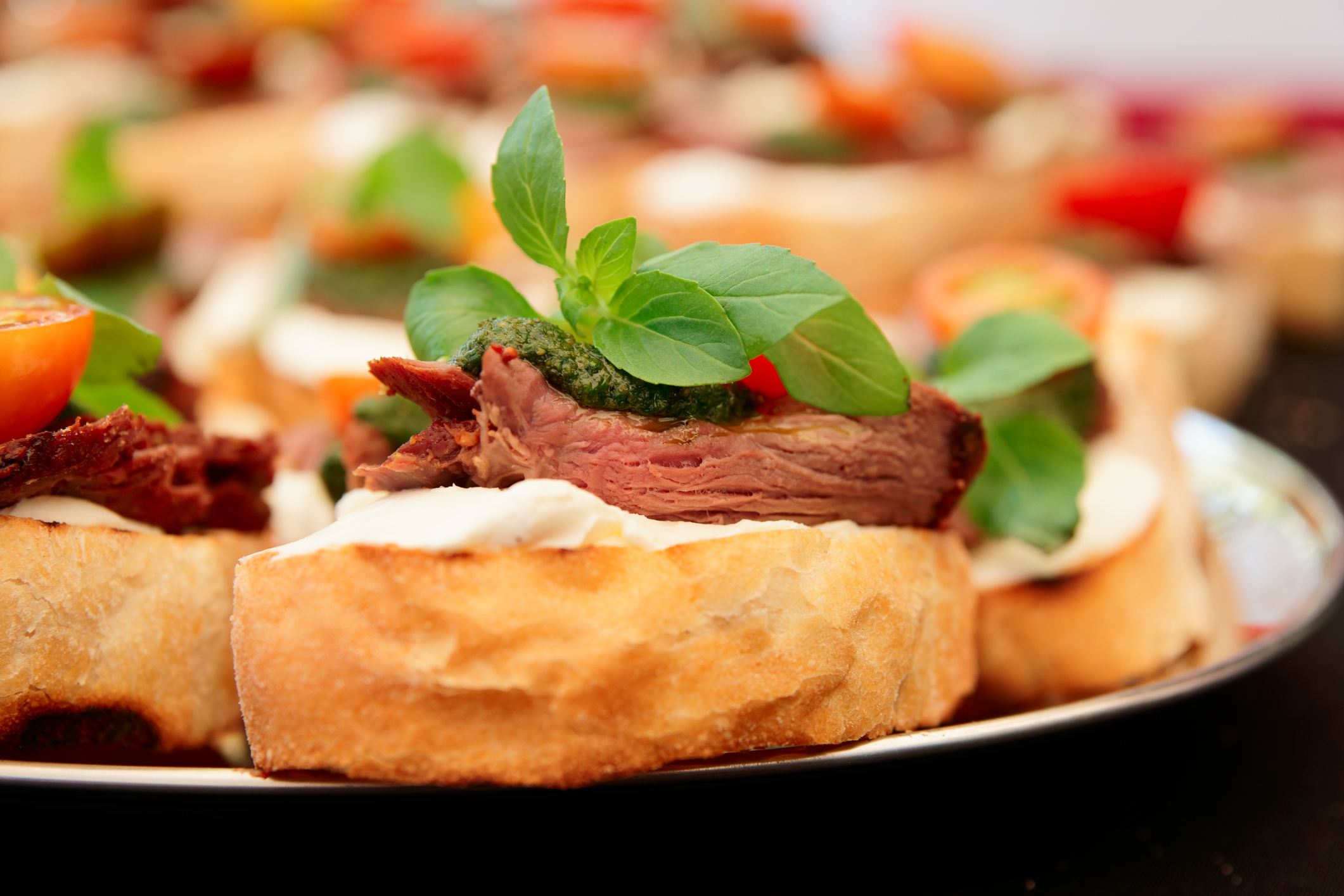 Bruschettas with beefsteak and pesto sauce, close-up