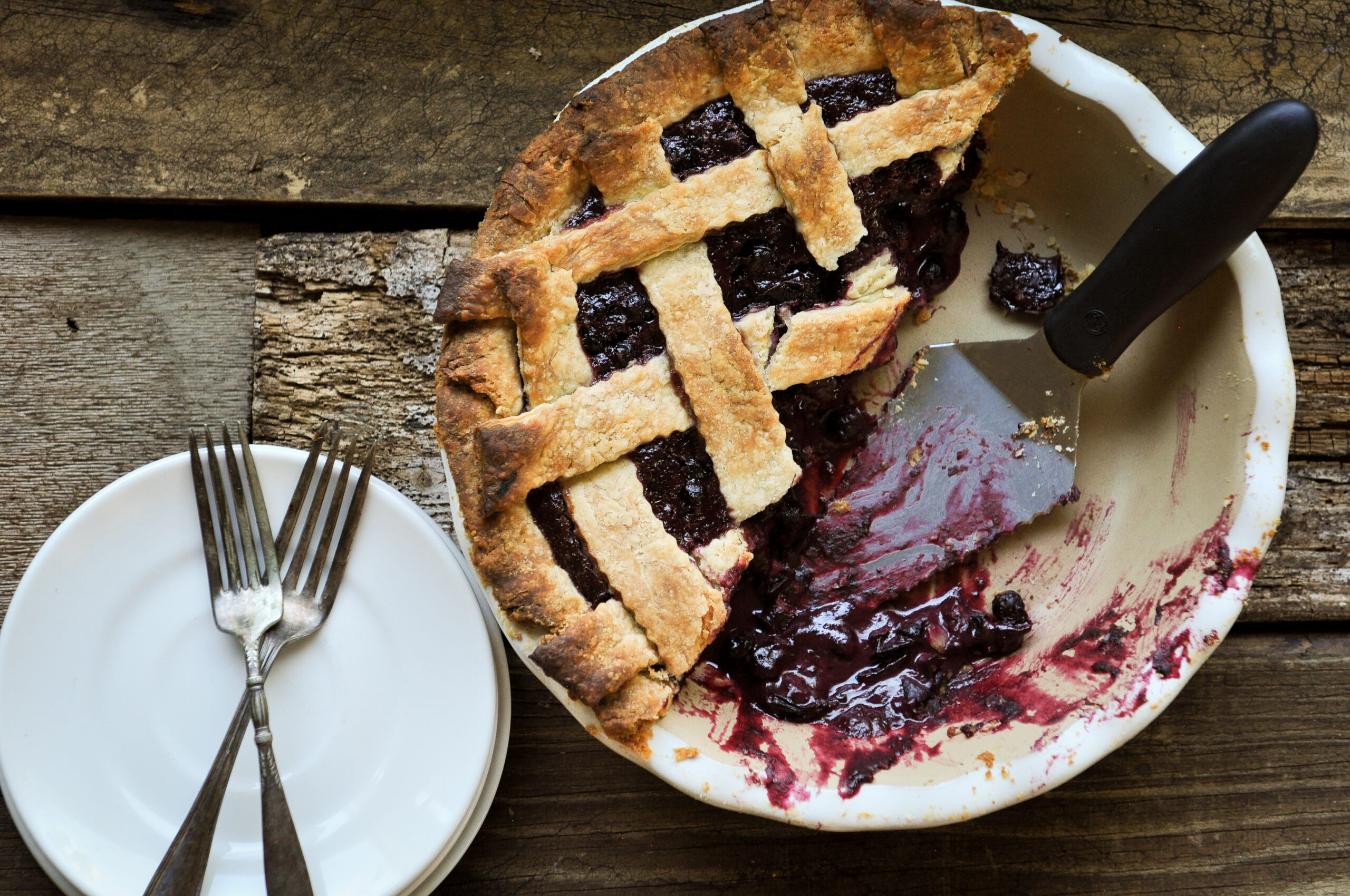 Top horizontal shot of lattice topped pie on stone pie plate on wood background