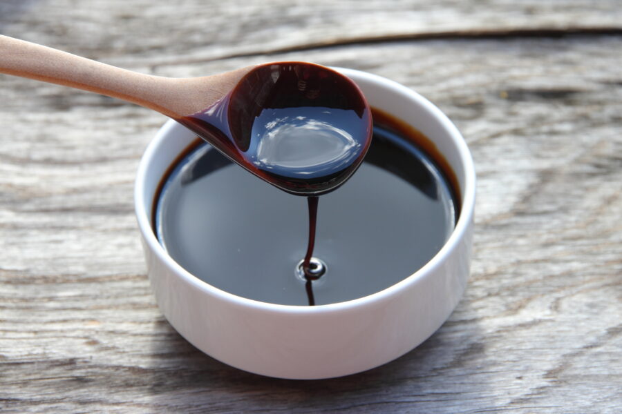 spoonful of molasses, dripping from spoon into a bowl