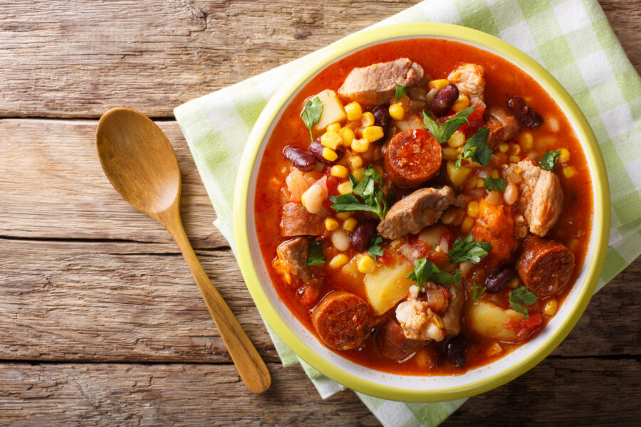 Cachupa stew with meat and vegetables close-up in a plate. horizontal top view from above