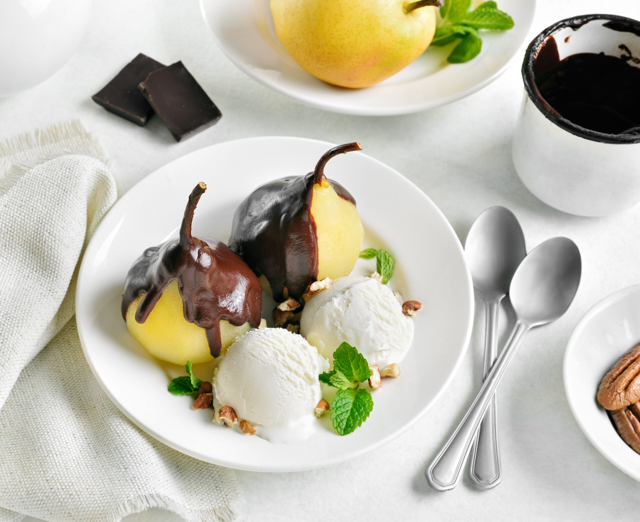 Poached pears with chocolate sauce and ice cream on white background. Close up view