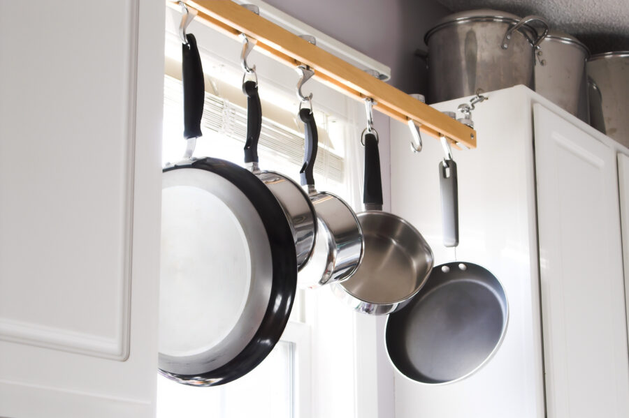 Pots and pans hanging from a rack in a kitchen.