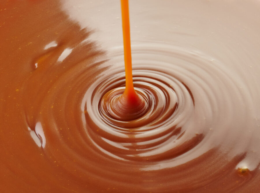 pouring caramel sauce on caramel background