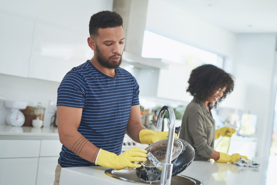 Shot of a young couple cleaning the kitchen together at home