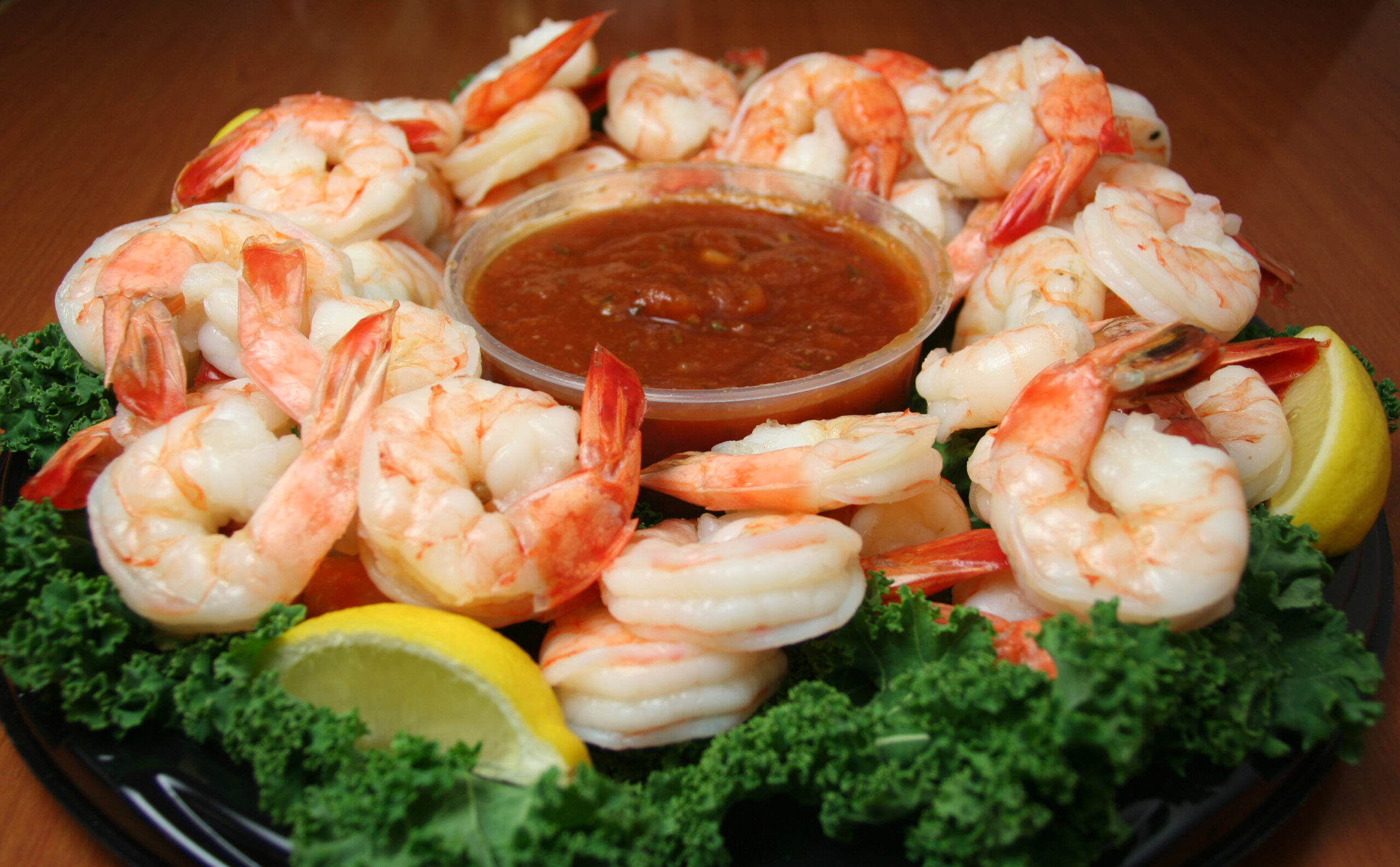 Shrimp cocktail appetizer served with lemon and cocktail sauce.