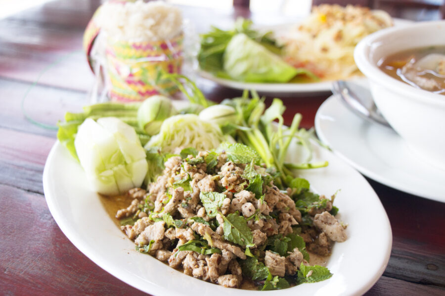 Spicy minced pork salad served on a white plate. Selective focus