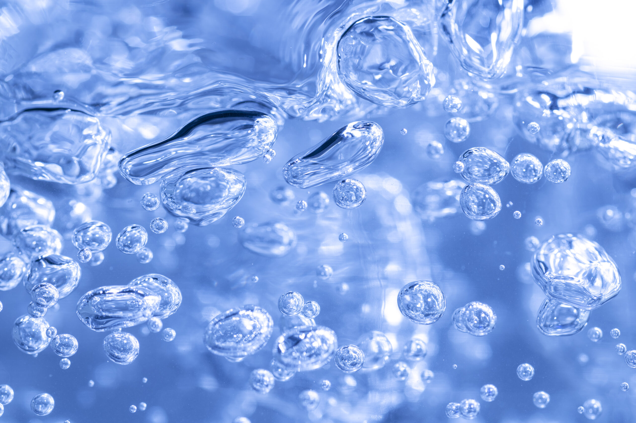 Transparent air bubbles in water in blue tone.