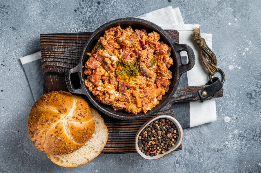 Turkish breakfast with Menemen omelet and bread. Dark background. Top view.