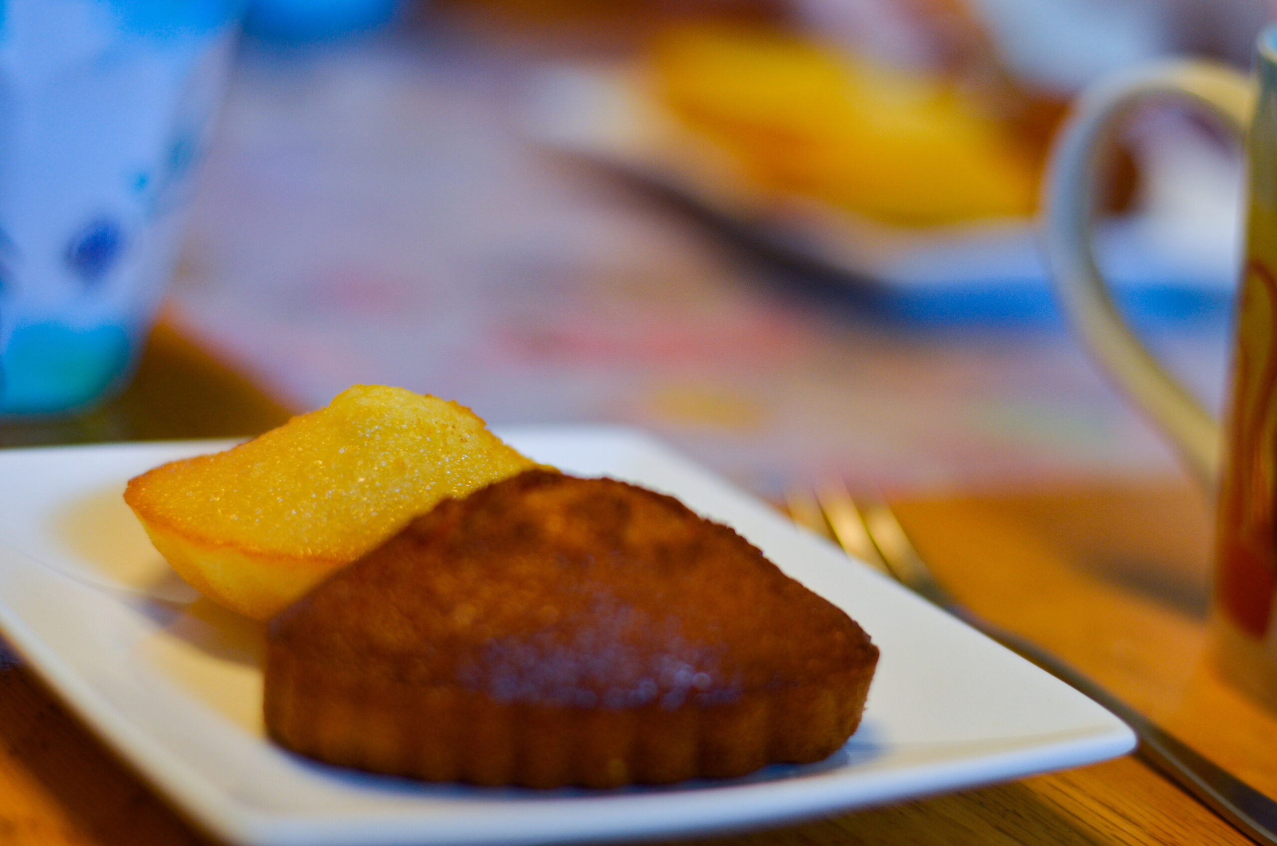 Two financiers lined up looking delicious. One is plain and one is chocolate flavored.