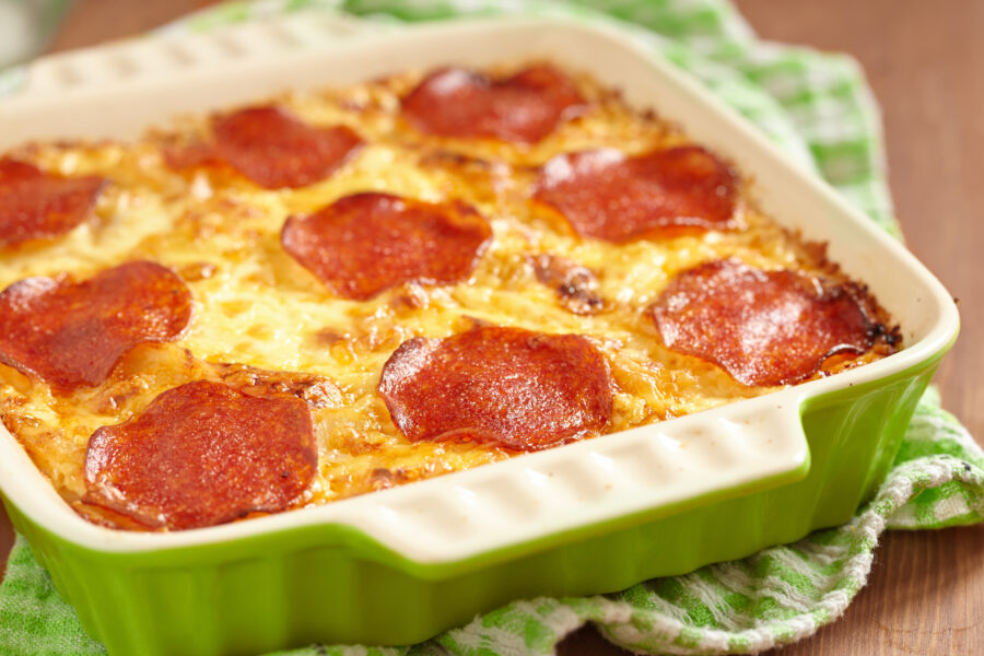 Casserole with pepperoni in green deep dish