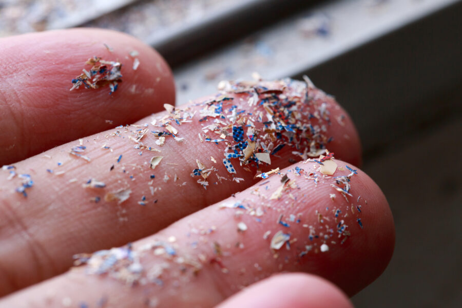 Close up side shot of microplastics laying on person's hand.