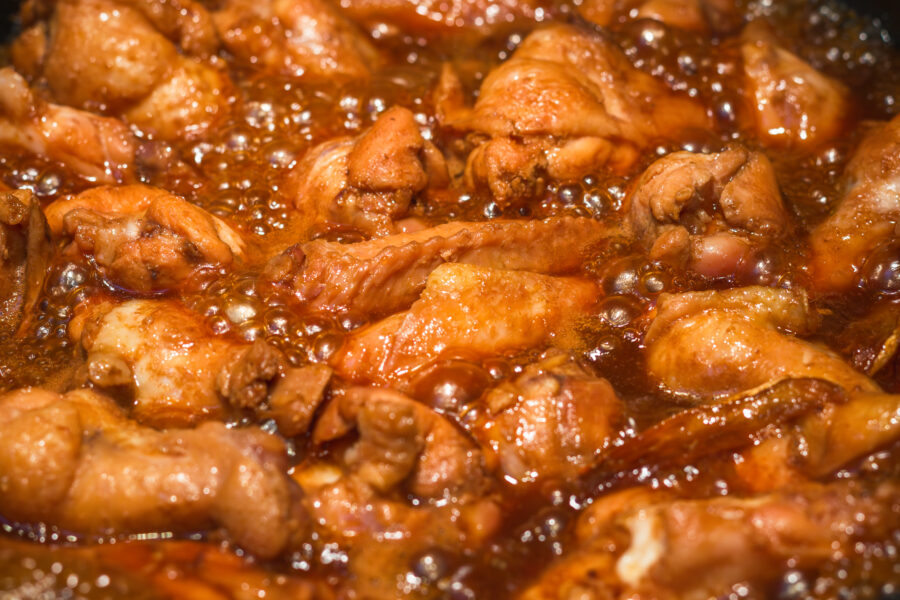 Cooking Chinese cuisine coca cola chicken wing in a pot, heating and bubbling