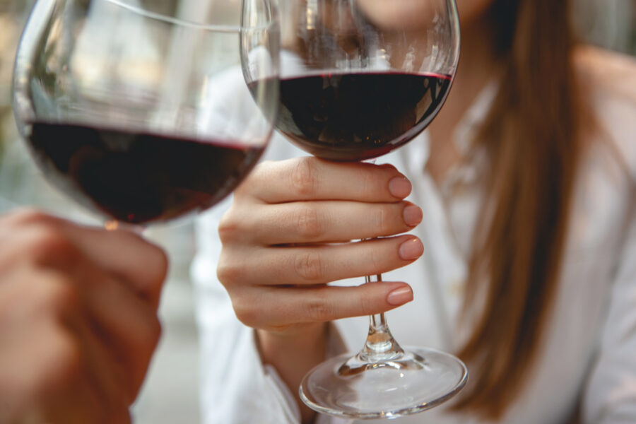 Friends toasting with red wine in outdoor restaurant