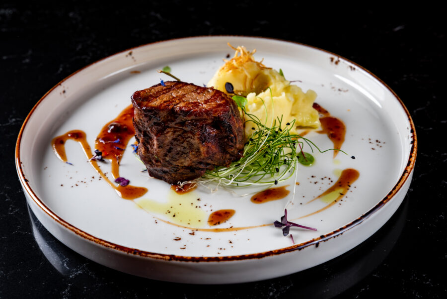 Grilled beef steak filet mignon with potato and sauce in plate