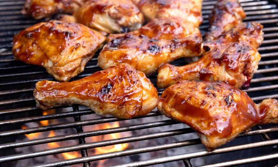 barbecued chicken roasting over open charcoal coals.