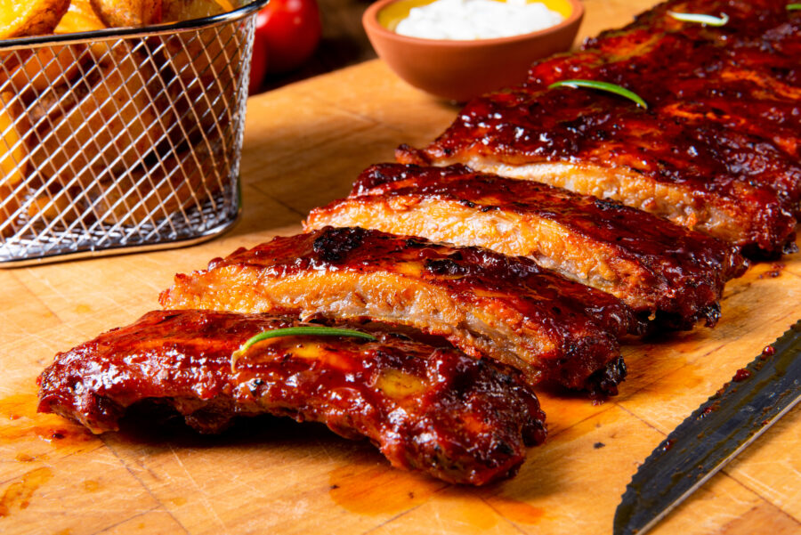 BBQ spare ribs from a charcoal grill on wooden cutting board