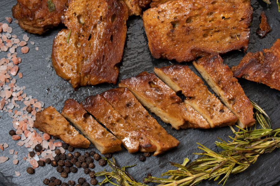 Roasted seitan steaks with herbs and spices on slate plate