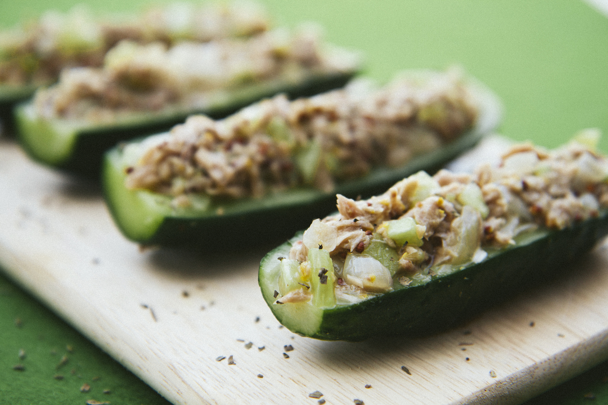 August 18, 2011 - Lithuania: cucumbers stuffed with tuna filling on a wooden cutting board - extreme close up, green background, selective focus, healthy eating