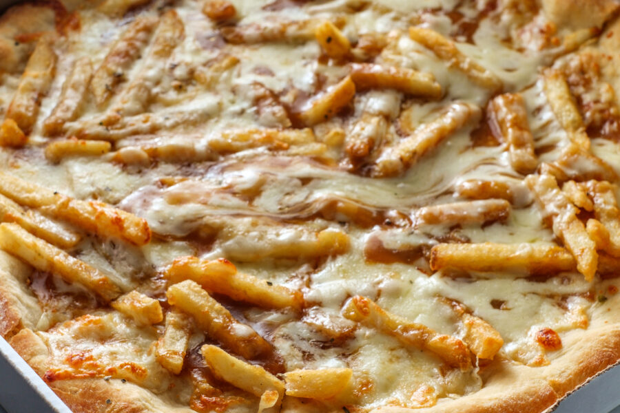 Top view of cheese pizza topped with poutine