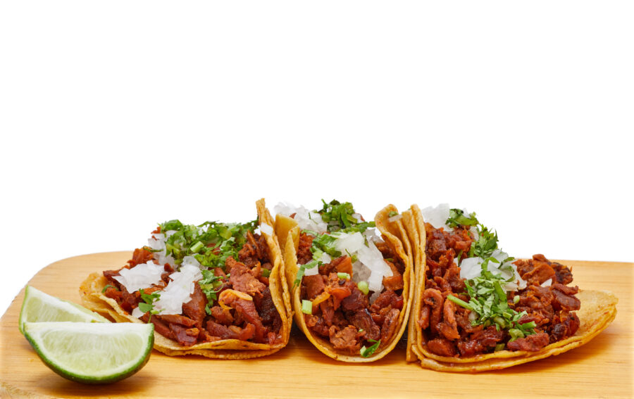 Tacos al pastor, traditional Mexican food, with onion, cilantro, pineapple, red sauce or guacamole.