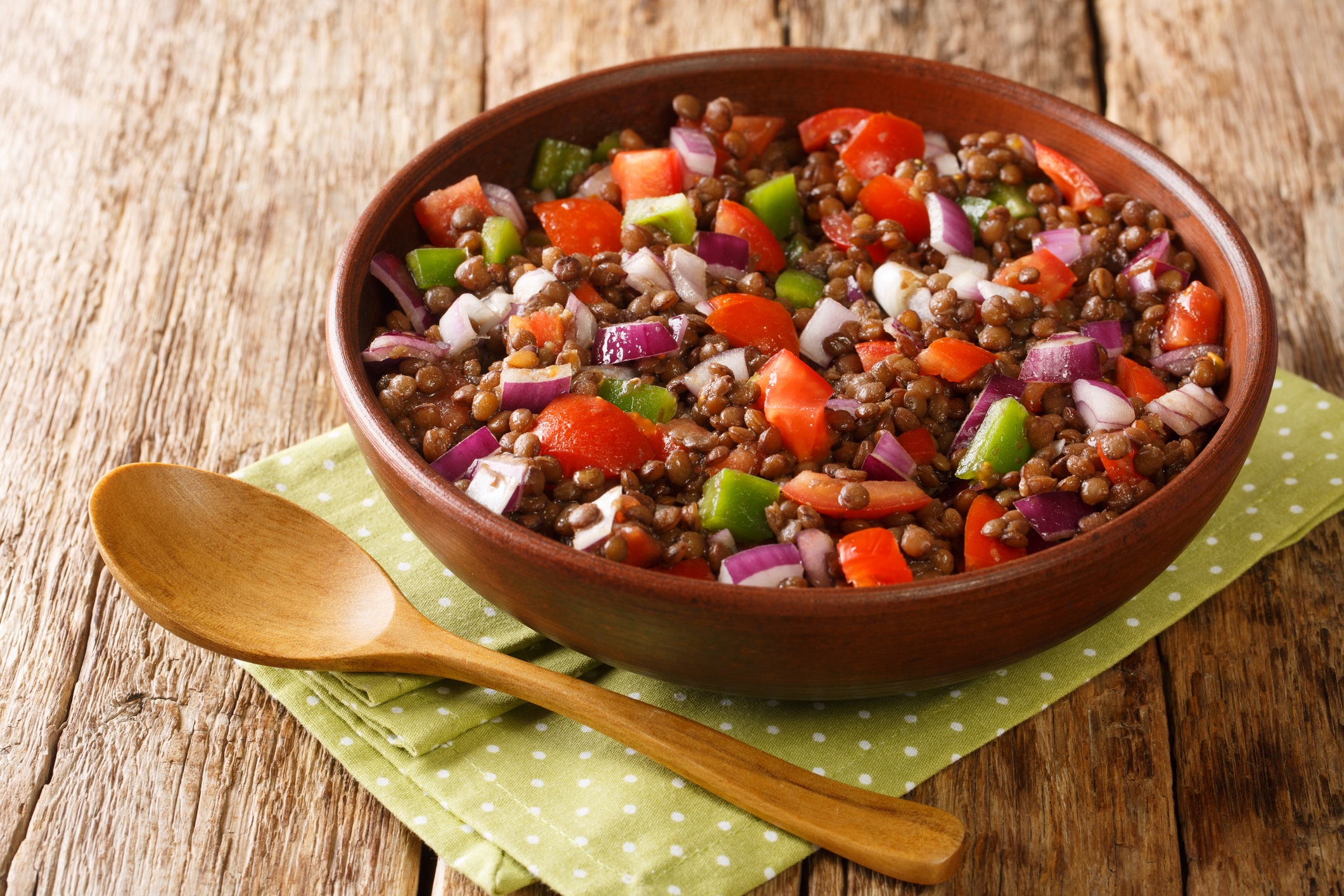 Azifa is a popular Ethiopian salad consisting of green lentils, finely chopped tomatoes, and onions close up in the plate on the table. Horizontal