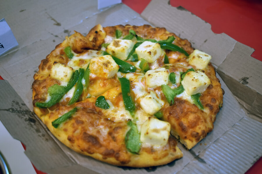 Pan Pizza freshly baked with lot of cheese and vegetable and paneer