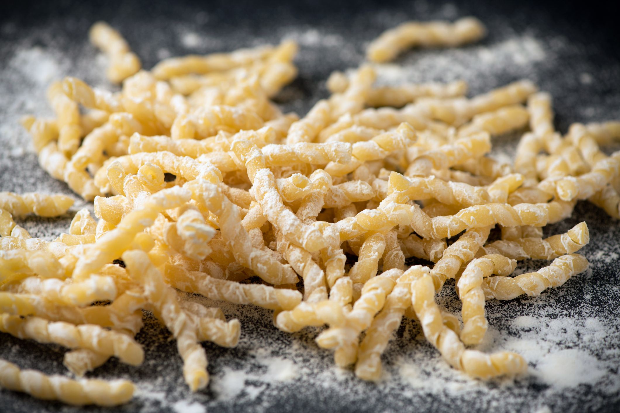 Raw pasta busiate on wooden table close up. Sicilian Trapani goodness