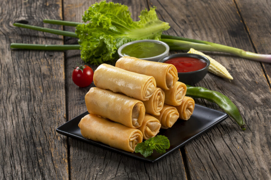 Fried spring rolls with sweet chili sauce and lime on plate