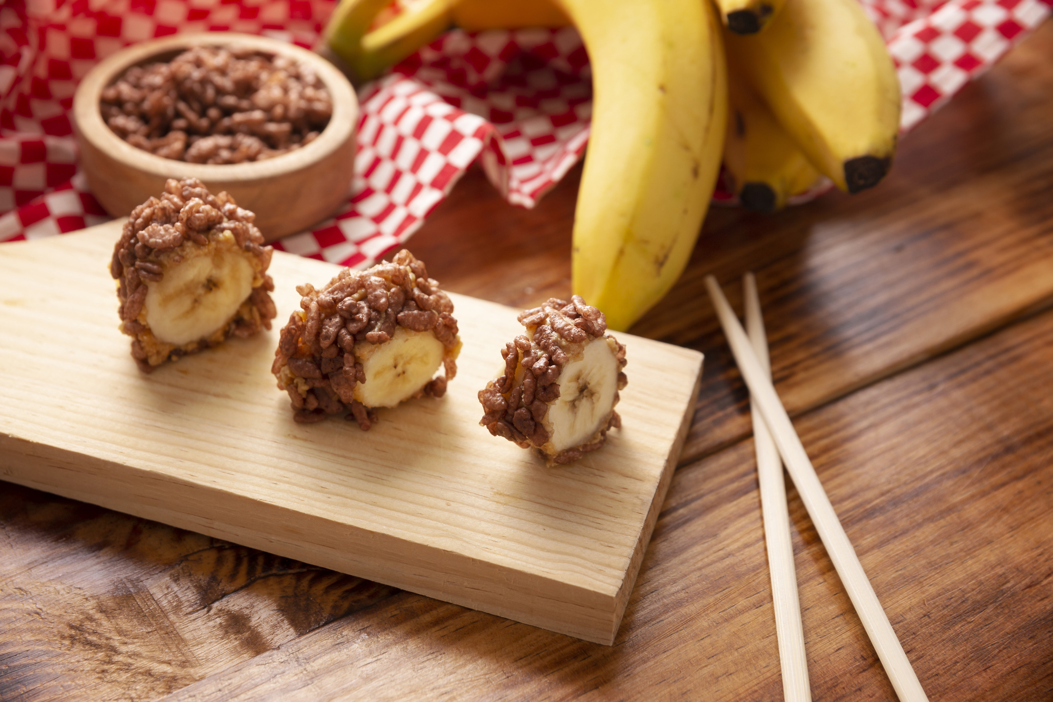 Banana sushi sweet rolls with caramel, peanut butter and chocolate puffed rice. Funny and easy homemade snack for kids and adults.