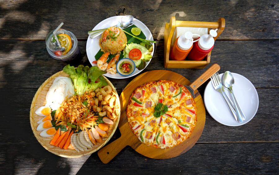 Pizza, Shrimp Fried Rice and Papaya Thai Street Food on Wood Table.