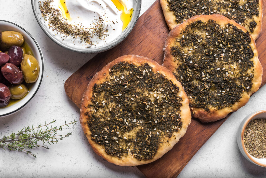 Manakeesh, arabic pizza, flat bread topped with zaatar spices close up.