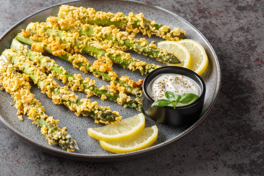 Baked Parmesan Asparagus Fries with panko close-up on a plate on a table. Horizontal