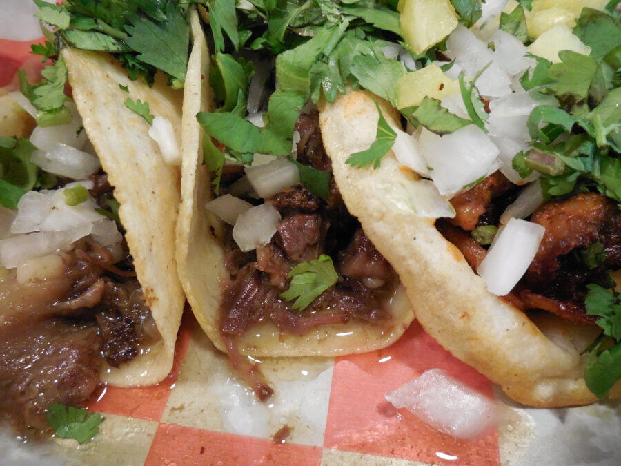 Close up of beef head and pastor tacos (tacos de cabeza y al pastor con piña)